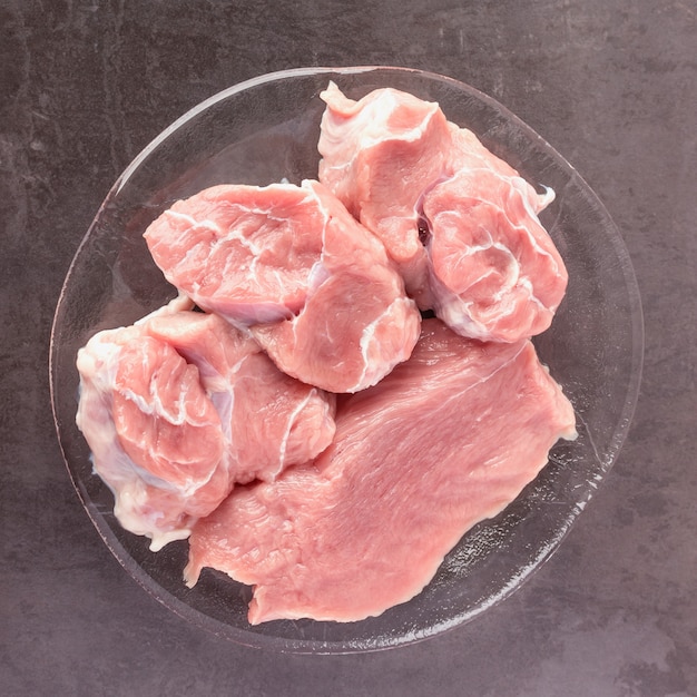 La carne cruda fresca se encuentra en la superficie de una piedra oscura. Concepto de cocina