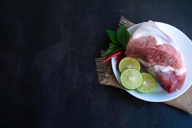 Carne cruda fresca y lima en una mesa de madera antigua