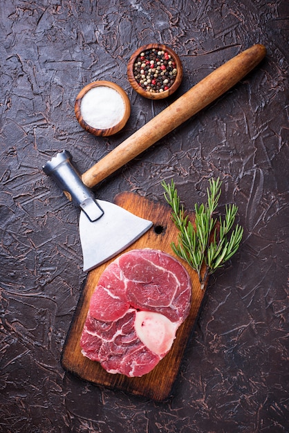 Carne cruda osso buco y carnicero hacha.