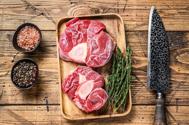 Carne cruda de la pierna de ternera cortada osso buco, cocinar ossobuco italiano