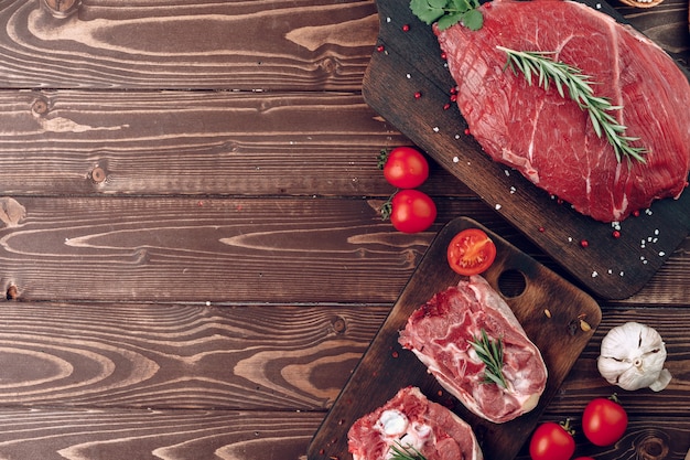 Carne cruda rebanadas de pierna de ternera sobre tablero de madera marrón cerrar