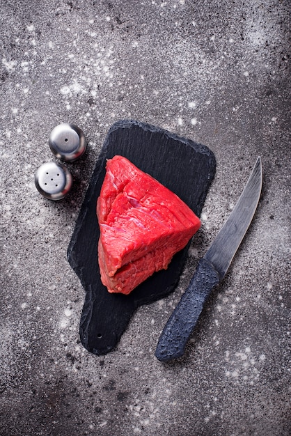 Carne cruda en tabla de cortar con especias