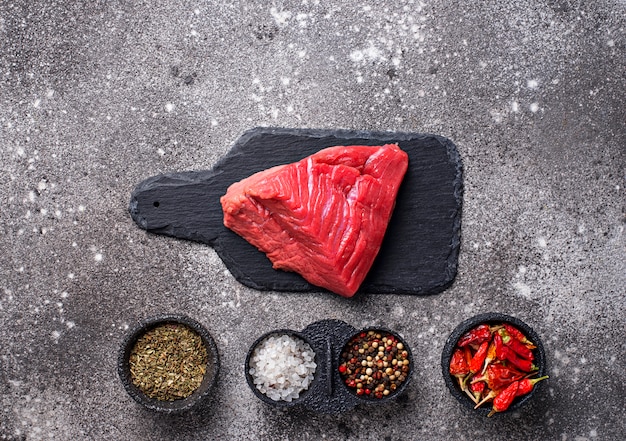 Carne cruda en tabla de cortar con especias