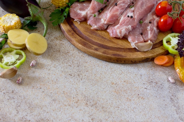 Carne cruda con verduras en una tabla para cortar