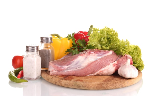 Carne cruda y verduras en una tabla de madera aislada en blanco