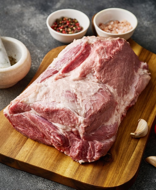 Carne de cuello de cerdo sobre una tabla de madera Cuello de cerdo crudo fresco con sal y pimienta