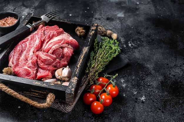 Carne de cuello de cordero o carne cruda Carne deshuesada en bandeja de madera Fondo negro Vista superior Espacio de copia