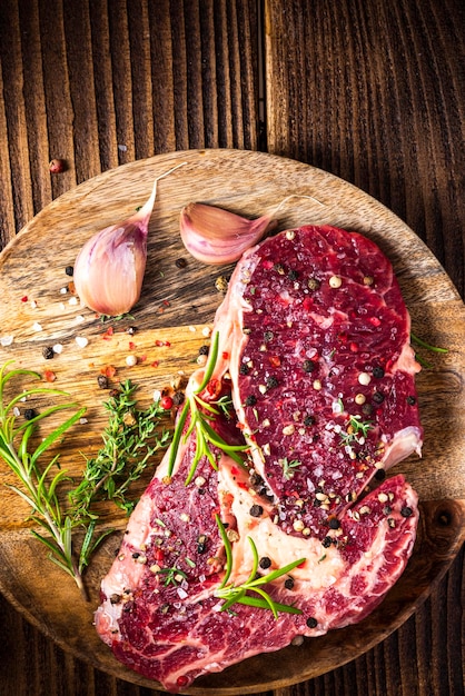 Carne de bife na placa de madeira com ervas e especiarias