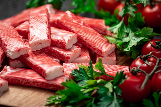 Carne de caranguejo fresca em uma tábua de cortar com salsa e tomate