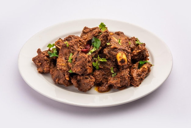 Carne de carneiro Sukha ou frango picante Murgh seco ou carne de cabra servida em um prato ou tigela