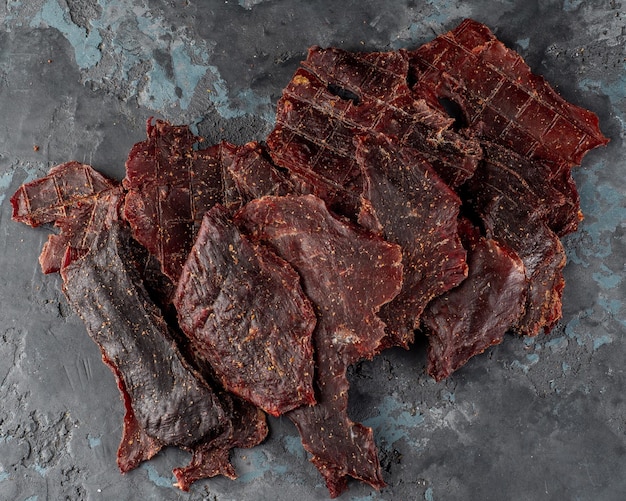 Foto carne de charque seca em um fundo escuro