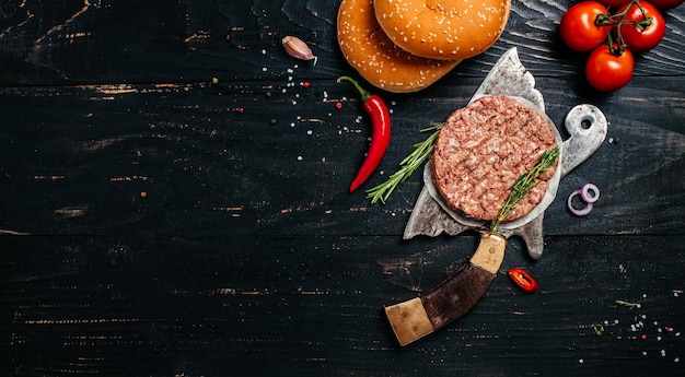 Carne de cordeiro carne crua à terra Costeletas de bife de hambúrguer no fundo escuro de madeira com cutelo. Formato de banner longo. vista do topo.