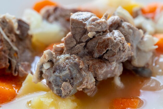 Carne de cordeiro cozida com batatas, cenouras, cebolas, vista superior, copie o espaço. Comida caseira de conforto de inverno.