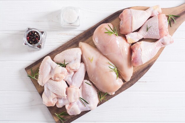 Foto carne de frango crua em fundo de madeira asas peito e pernas