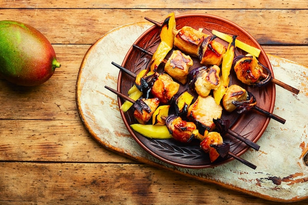 Carne de frango frito em espetos de madeira. Shashlik com manga