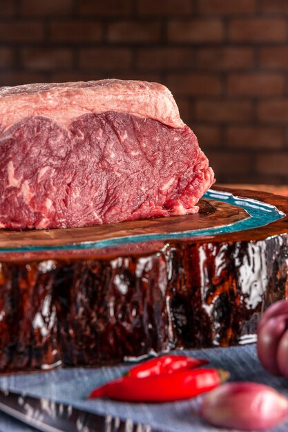 Foto carne de lombo de tira crua (chouriço argentino) em uma placa de corte de madeira resinada - close up.