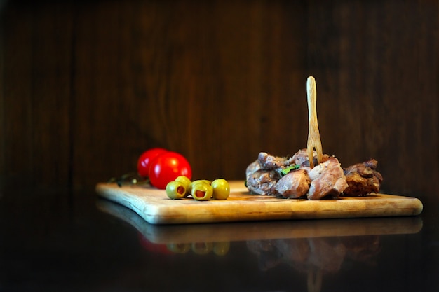 Carne de pato com tomates e azeitonas em uma placa de madeira comida saborosa gourmet e conceito de cozinha