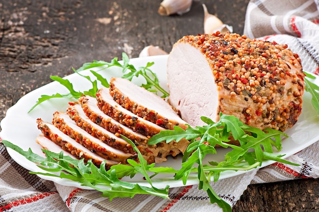 Carne de porco assada decorada com folhas de rúcula