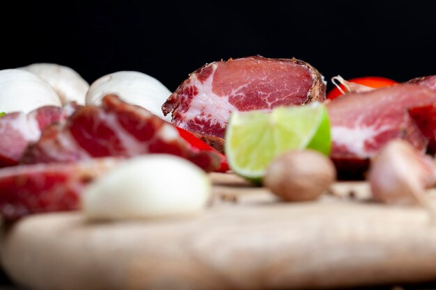 Carne de porco e bacon fatiados durante o cozimento de carne seca cortada em pedaços em uma tábua de corte