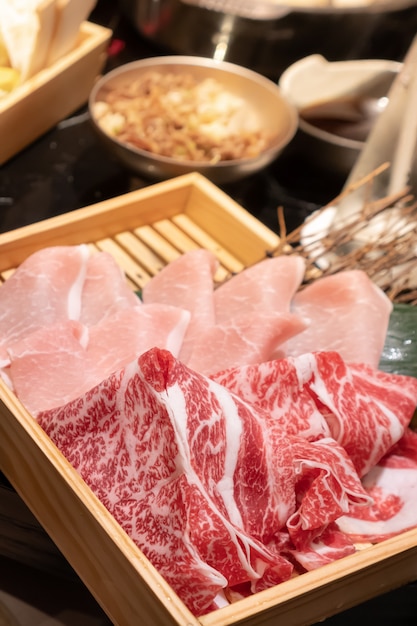 Carne de porco e carne bovina fresca cozida em uma caixa quadrada de madeira que se prepara para Shabu