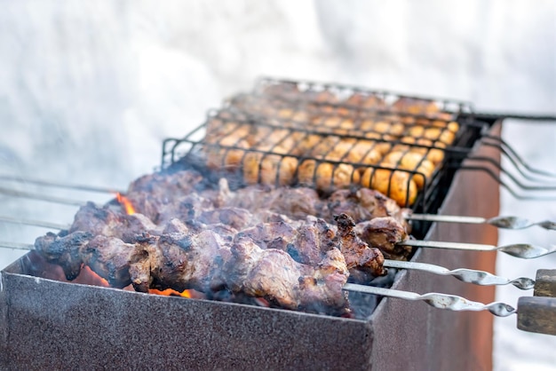 Carne de porco em espetos e cogumelos em uma grelha grelhada no inverno