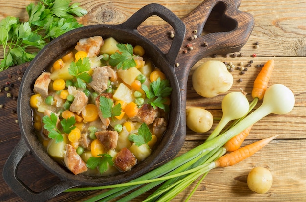 Carne de porco estufada com legumes. em uma panela de ferro fundido