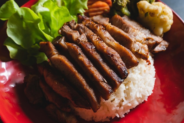 Foto carne de porco grelhada à moda tailandesa com arroz e carne vegetal para jantar ou almoço pratos principais