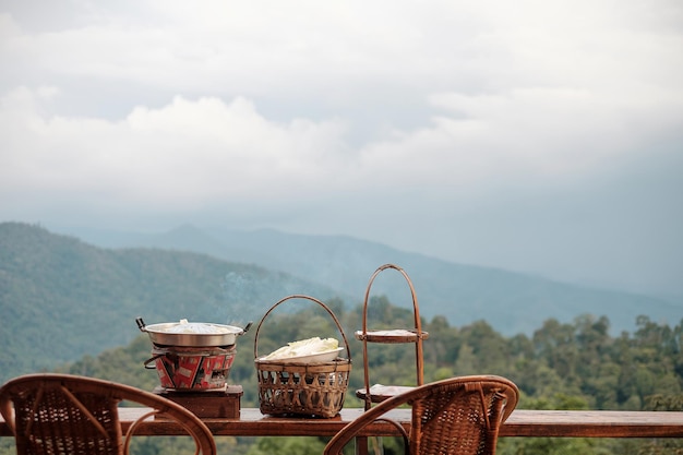 Carne de porco ou carne com legumes e sopa na frigideira quente com vista para a montanha de fundo, o tradicional churrasco tailandês é famoso na tailândia