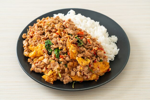 Carne de porco picada frita com manjericão e ovo coberto com arroz - comida asiática