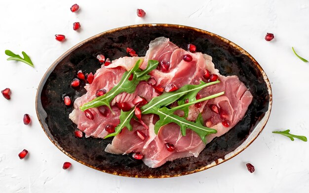 Carne de vaca carpaccio com sementes de rúcula e romã isoladas em fundo branco