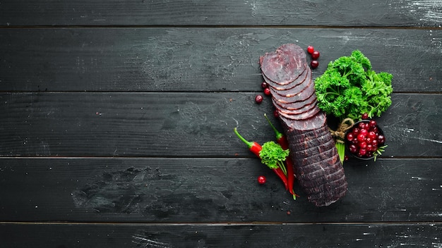 Carne de vitela seca com especiarias e ervas Carne seca na velha mesa preta Vista superior Espaço livre para o seu texto