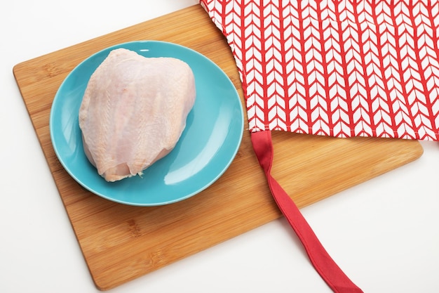 Carne dietética Pechuga de pollo cruda sobre una mesa en un plato azul