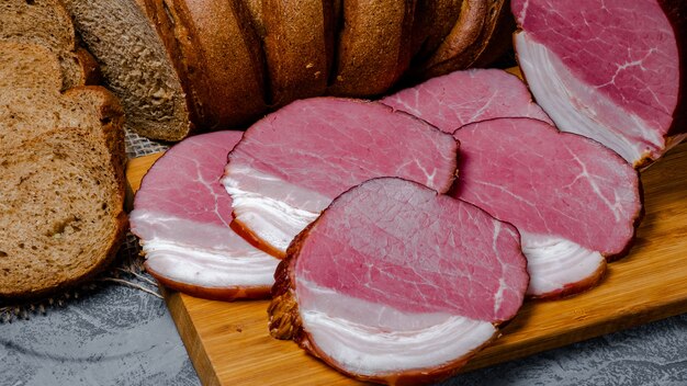 Carne e pão fumado com farelo no fundo de madeira