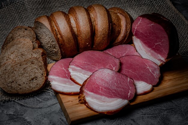 Carne e pão fumado com farelo no fundo de madeira