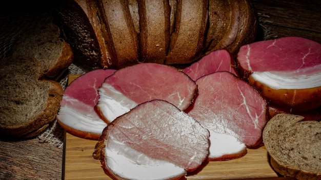 Carne e pão fumado com farelo no fundo de madeira