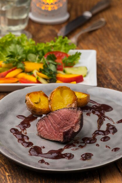 Carne y ensalada servidas en platos en la mesa