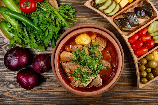 Carne con estofado de patata servido en plato sobre fondo oscuro