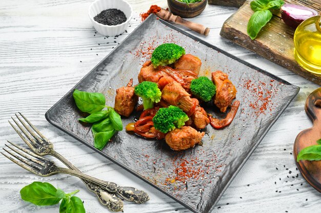 Carne estufada em molho de vinho com brócolis e legumes na placa de pedra preta Vista superior