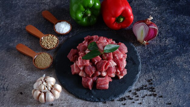 Carne fresca com alguns ingredientes Servida em prato de pedra com fundo escuro Bife