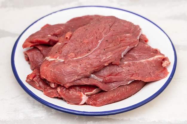 Carne fresca crua com pimenta no prato branco