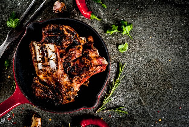 Carne fresca crua, cordeiro assado ou grelhado ou costelinha com molho de tomate vermelho, pimenta, alho e especiarias na frigideira