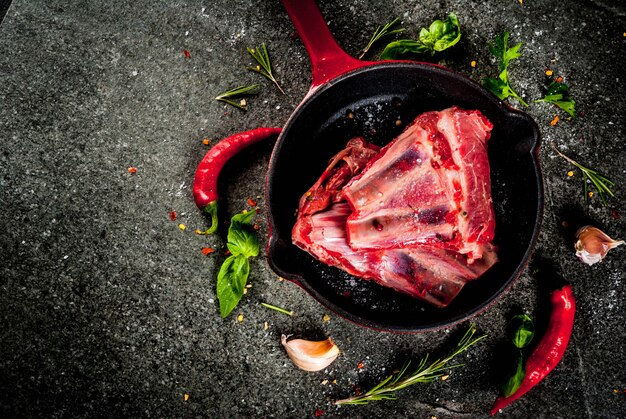 Carne fresca crua, cordeiro cru ou costelas com pimenta, alho e especiarias na frigideira frigideira