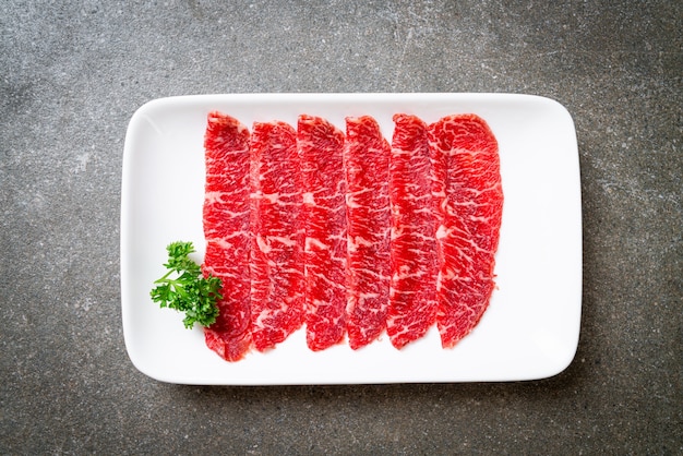 carne fresca cruda en rodajas con textura marmolada servida para Sukiyaki y Shabu o Yakiniku