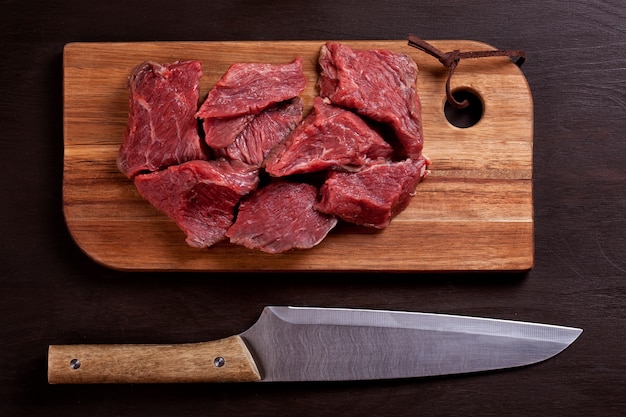 Carne fresca cruda en tablero de madera listo para cocinar