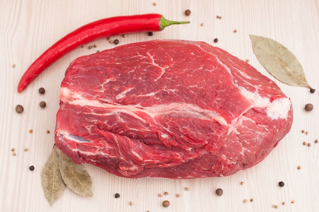 Carne fresca de bovino vermelha crua com especiarias na mesa de madeira