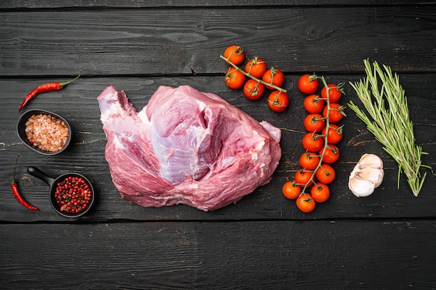 Carne fresca con hierbas, aceite y especias, sobre fondo de mesa de madera negra, vista superior plana, con espacio para copiar texto