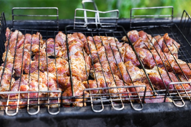 Carne fresca para churrasco frito no fogo Foco seletivo Carne de porco grelhada Cozinhar churrasco na grelha com fumaça Piquenique na natureza Alimentação saudável e nutrição adequada