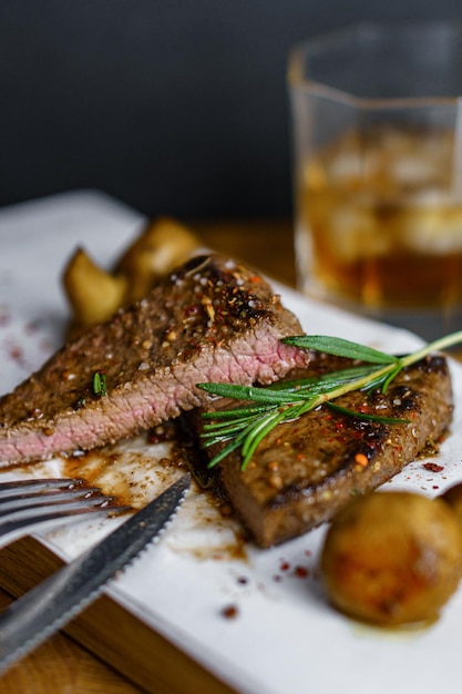 Carne fresca a la parrilla Bistec de ternera medio raro con brunch de romero y champiñones en tabla de cortar de madera