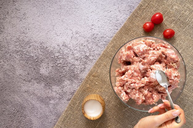 Carne fresca, picada en una placa en la tabla en la cocina. Cocinando carne picada para las albóndigas.