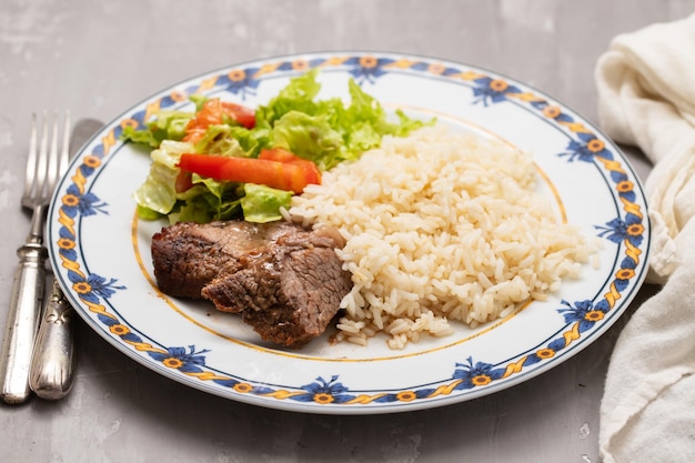 Carne frita al horno con arroz hervido y ensalada fresca